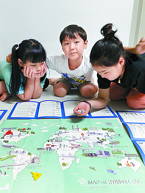 박준수 팀장의 세 자녀가 지도를 펼쳐놓고 부루마블 게임을 하고 있다.